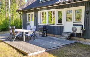 VästergarnにあるBeautiful Apartment In Gotlands Tofta With 3 Bedroomsのデッキにテーブルと椅子が備わるキャビン