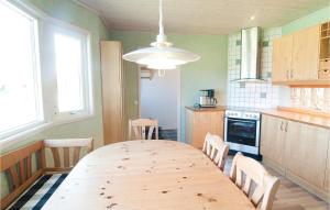 a kitchen with a wooden table and chairs in it at Lovely Apartment In Gotlands Tofta in Västergarn