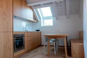 a kitchen with wooden cabinets and a table and a window at Residence Hotel Casa Alpina Serrada in Folgaria