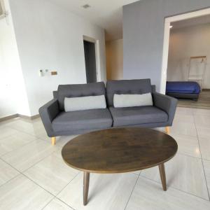 a living room with a couch and a coffee table at Octagon Premium Ipoh Town Center 2BR 121 by Grab A Stay in Ipoh