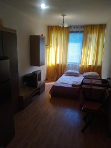 a bedroom with two beds and a flat screen tv at Апартмент Паисий 15 in Varna City