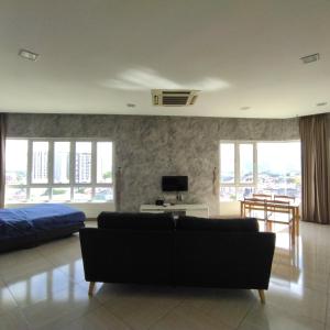 een woonkamer met een bank en een bed bij Octagon Premium Ipoh Town Center 2BR 121 by Grab A Stay in Ipoh