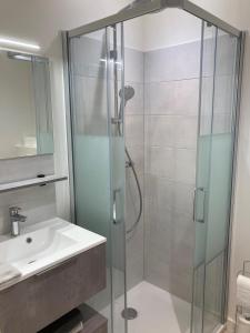 y baño con ducha acristalada y lavamanos. en La Maison du Cocher - Studio climatisé en Hypercentre, en Angers