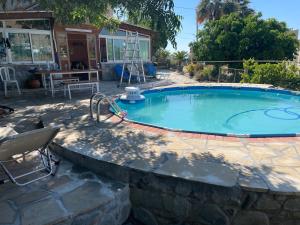 a large swimming pool with a stone wall around it at Miltos Apartment in Argaka