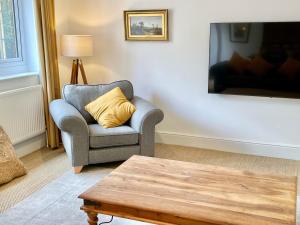 a living room with a chair and a coffee table at Rye Court Cottages in Helmsley