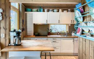 uma cozinha com armários brancos e um balcão de madeira em 4 Bedroom Stunning Home In Melandsj em Melandsjøen
