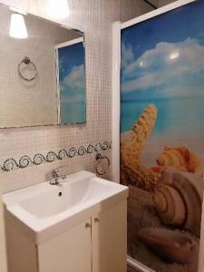 ein Badezimmer mit einem Waschbecken und einem großen Wandgemälde in der Unterkunft Apartamentos El Patio Andaluz in Jerez de la Frontera + 78 Fotos