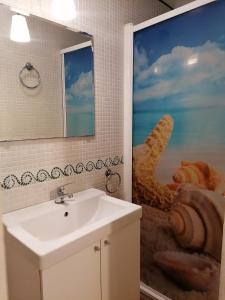 ein Badezimmer mit einem Waschbecken und einem großen Wandgemälde in der Unterkunft Apartamentos El Patio Andaluz in Jerez de la Frontera