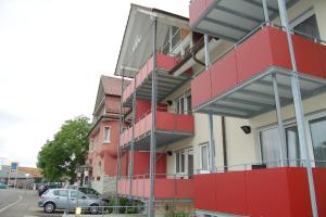 un edificio rojo y blanco con un coche estacionado al lado en Gasthof Seerose, en Radolfzell am Bodensee