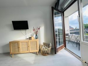 a living room with a tv and a table with a chair at Apartment Strandkorv für 2-4 Personen mit Pool in Dahme