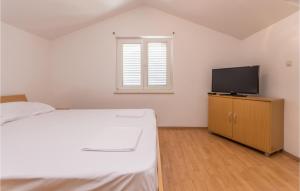 een slaapkamer met een bed en een flatscreen-tv bij Cozy Apartment In Pakostane With Wifi in Pakoštane