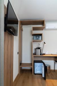 ein Wohnzimmer mit einem Schreibtisch, einem TV und einem Schreibtisch in der Unterkunft ZIEGELHÜSI Hotel, Stettlen bei Bern in Bern