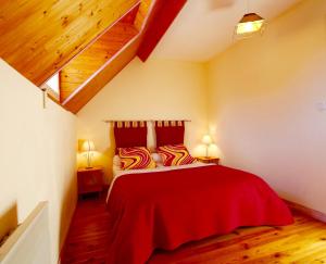 una camera da letto con letto con lenzuola rosse e pavimenti in legno di GS3 DUPLEX 4 PERS TERRASSE 5mn LUZ 15mn ARDIDEN a Sassis