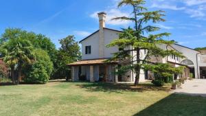 una gran casa blanca con un árbol en el patio en B&B Al Vecio Morer, en San Donà di Piave