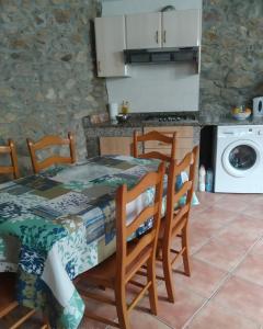 comedor con mesa y sillas y cocina en Apartamento A Nave, en Finisterre