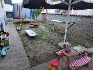 un patio con sombrilla, mesa y sillas en Apartman Anastasija en Surčin