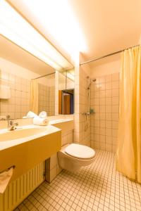 a bathroom with a sink and a toilet and a mirror at Michels Gästehaus Meerzeit in Norderney