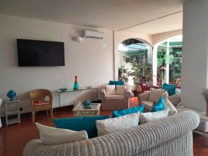 sala de estar con muebles azules y blancos y TV en Hotel Il Vascello, en Marina Serra