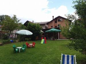 un cortile con sedie, tavoli e ombrellone di Apartman Dalal - with access to river Una a Bihać