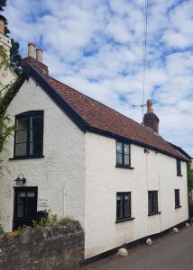 Biały dom z czarnymi oknami i dachem w obiekcie Bay Tree Cottage w mieście Langford