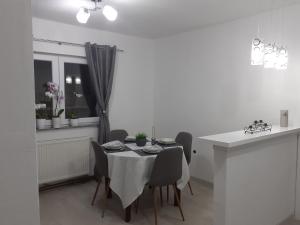 una sala da pranzo con tavolo e sedie bianchi di Apartman Dalal - with access to river Una a Bihać