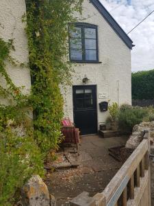 een huis met een zwarte deur en een rode bank bij Bay Tree Cottage in Langford