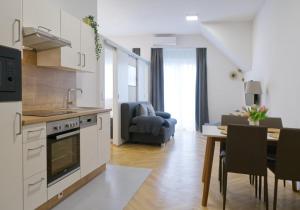 a kitchen and living room with a table and a couch at AAA All About Apartments in Vienna