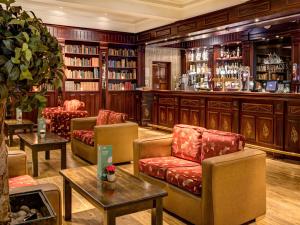 a library with chairs and tables and a bar at Everglades Hotel in Derry Londonderry