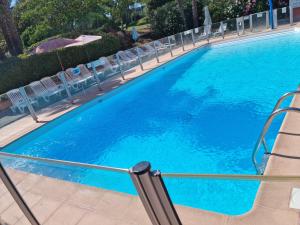 a large pool with chairs and blue water at Maison de Vancances à louer Alpes Maritimes in Mouans-Sartoux