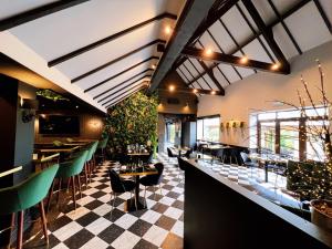 a restaurant with a checkered floor and tables and chairs at The Chesterton Hotel in Bicester