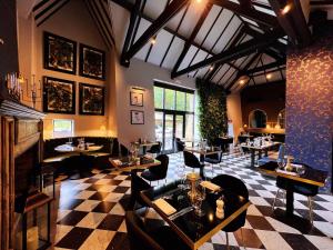 a restaurant with a checkered floor and tables and chairs at The Chesterton Hotel in Bicester