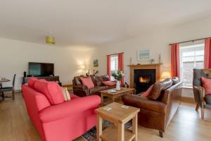 a living room with red furniture and a fireplace at Pant Farmhouse in Ayr
