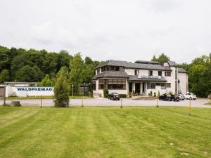 un bâtiment avec une pelouse devant lui dans l'établissement Landhaus Sundern, à Tecklembourg