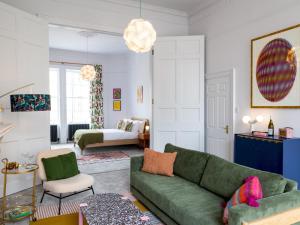 a living room with a green couch and a bedroom at Pass the Keys Stunning one bed apartment in central location in Bath