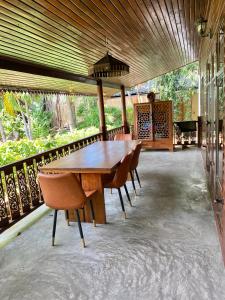 Baan Laem Noi Villa's في شاطئ مينام: طاولة وكراسي خشبية على الفناء