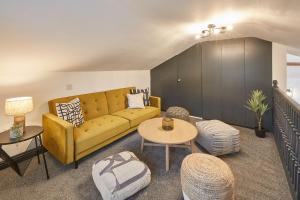 a living room with a yellow couch and a table at Host & Stay - The Annexe @ The Old Brewery in Richmond