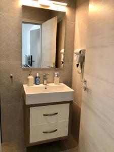 a bathroom with a sink and a mirror at Modern and New Apartments in North of Timisoara - PNM Residence in Dumbrăviţa