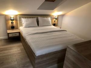 a bedroom with a large bed with white sheets and pillows at Modern and New Apartments in North of Timisoara - PNM Residence in Dumbrăviţa