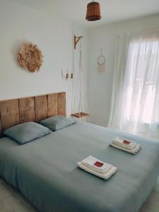 1 dormitorio con 1 cama grande y toallas. en Les soleils de la Loire, en Ingrandes