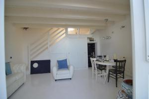 a living room with a couch and a table and chairs at Il pesce nero in Portopalo