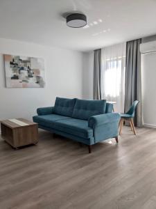 a living room with a blue couch and a table at Modern and New Apartments in North of Timisoara - PNM Residence in Dumbrăviţa