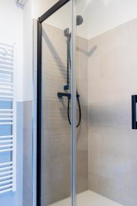 a shower with a glass door in a bathroom at Strandnahe Ferienwohnung - sehr modern und hochwertig eingerichtet, inklusive Parkplatz, Gartenzugang und Fahrradunterstellmöglichkeit in Scharbeutz