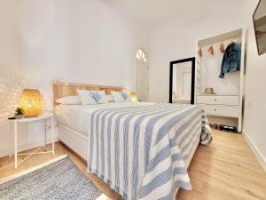 a bedroom with a bed with a blue and white striped blanket at Vista Azul in Acantilado de los Gigantes