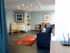 sala de estar con sofá azul y mesa en Suite Minerva, en Polignano a Mare
