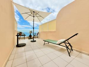 een patio met een tafel en een parasol bij Vista Azul in Acantilado de los Gigantes