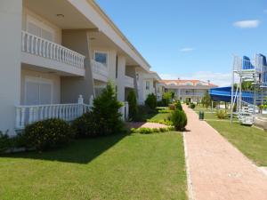 a house with a brick sidewalk next to a yard at Sadev Turizm Belek Family Villas in Belek