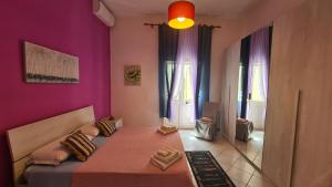 a bedroom with a bed with a purple wall at Casa Rosa in Sogliano Cavour