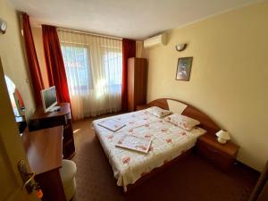 Habitación de hotel con cama y TV en Семеен Хотел Бачково, en Bachkovo