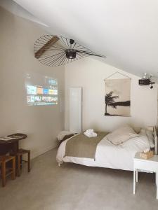 um quarto com uma cama e uma ventoinha de tecto em La Parenthèse, joli studio avec terrasse em Valeuil