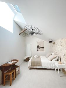 a white bedroom with a bed and a skylight at La Parenthèse, joli studio avec terrasse in Valeuil